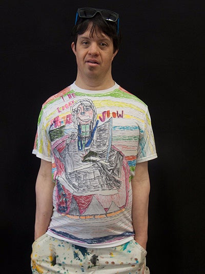The artist, Pablo Rahner, a latino man, wearing his art t-shirt with a Rocky Horror design on it