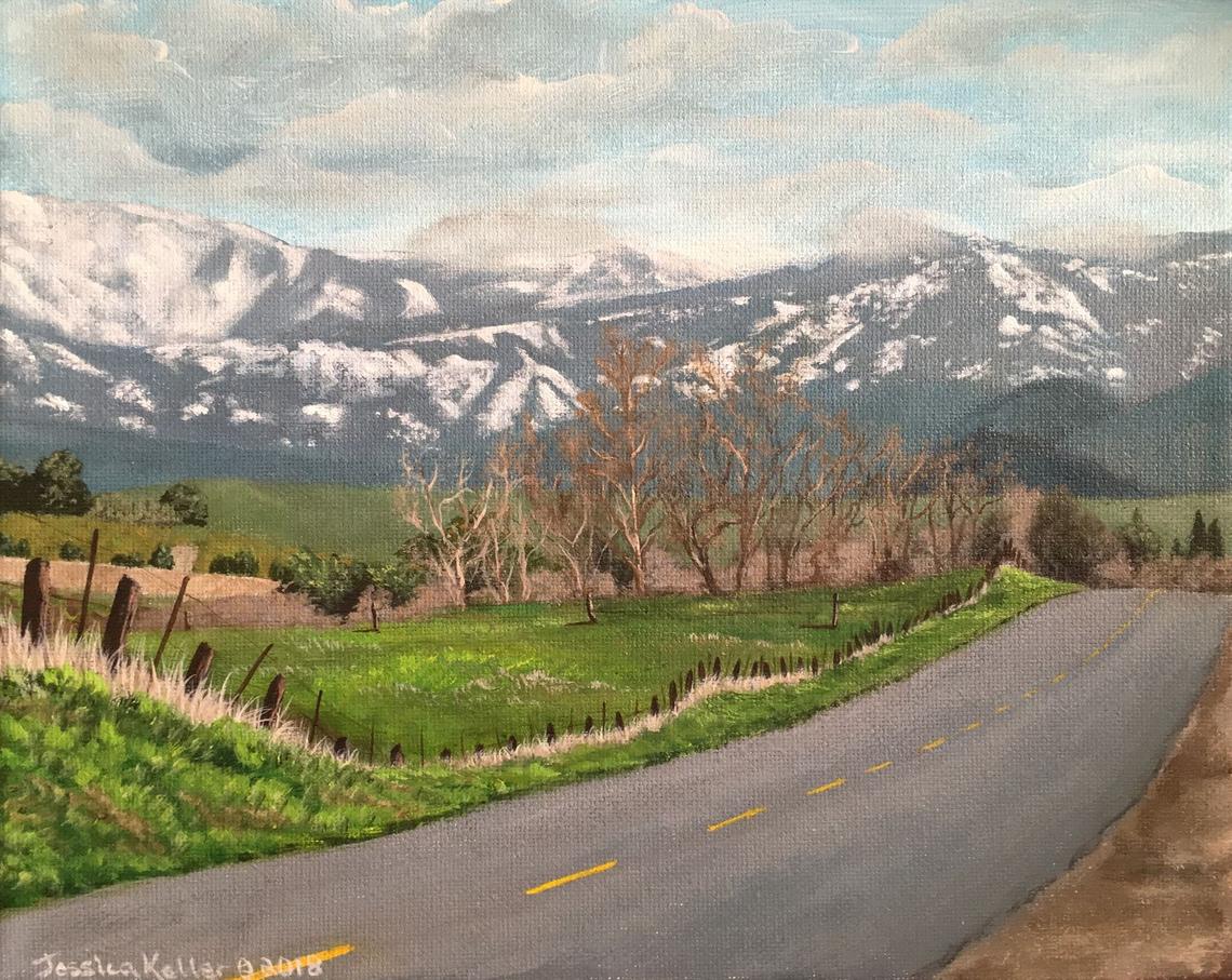 An acrylic painting of a paved two-lane country road leading into the painting toward a snow covered Sierra Nevada Mountain range. To the left the painting is an old wooden fence that runs alongside the road. The left of the painting opens to a field of grass, leafless trees, a distant orchard and rolling foothills. The blue sky is scattered with clouds.
