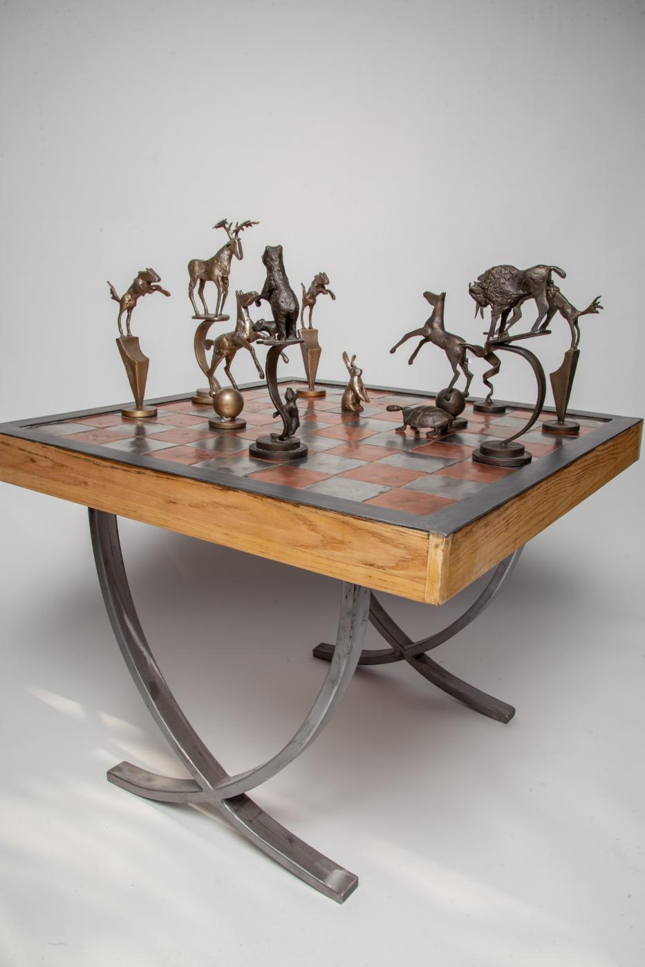 Forged in fire, my chess set is my interpretation of chess pieces as wild animals of North America. My design is inspired by my life spent outdoors, working and playing in the American mountains and deserts. I brought those days under the sun and stars into the feeling of my series of thirty-two sculptures which together create the chess set. My time camping and working in National and State Parks inspired the name, ‘Yellowstone”. My set is oversized and all-together, heavy.