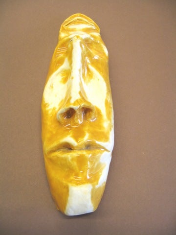  A face mask, glazed in yellow and white.