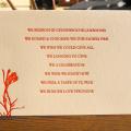 Photo of a postcard with orange text and a flower on the bottom left.